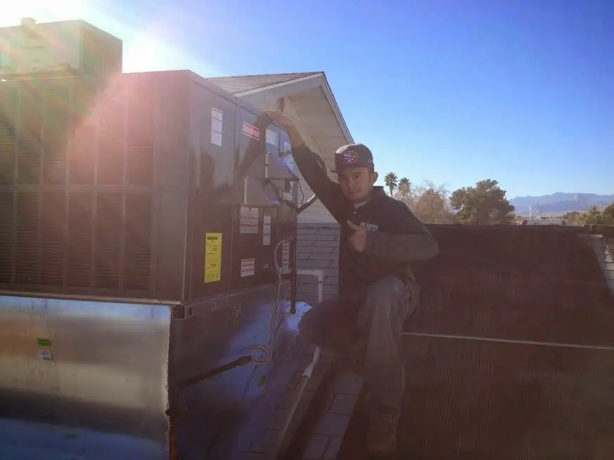 HVAC technician performing AC Tune-Up on a rooftop unit in Heber